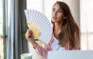 Blogartikel Titelbild: Frau im Büro bei Hitze