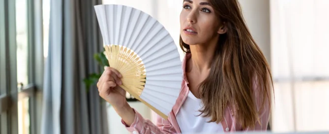 Blogartikel Titelbild: Frau im Büro bei Hitze